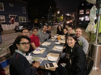 Group photo of lab members at table.
